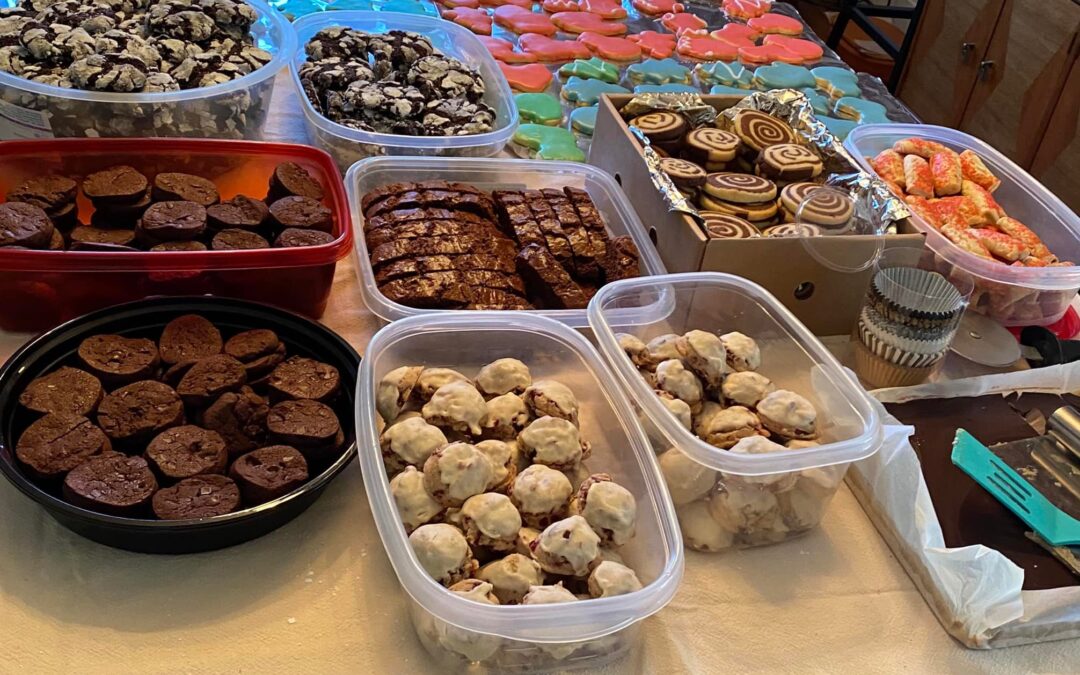 Dozens of holiday cookies in containers on a table